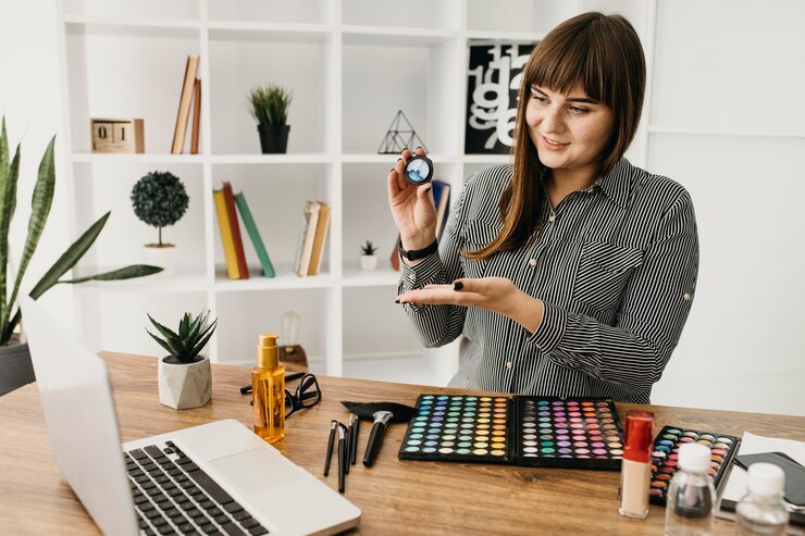 Foto gratuito blogger de maquillaje femenino con streaming con portátil en casa