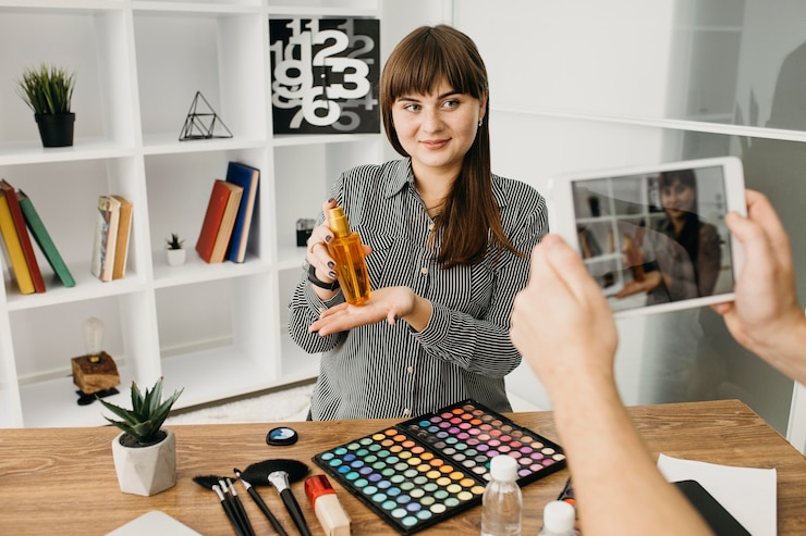Foto gratuito blogger de maquillaje femenino con streaming con tableta en casa