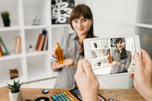 Foto gratuita blogger de maquillaje femenino con streaming con tableta