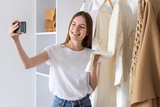 Blogger mostrando su ropa y usando un teléfono inteligente