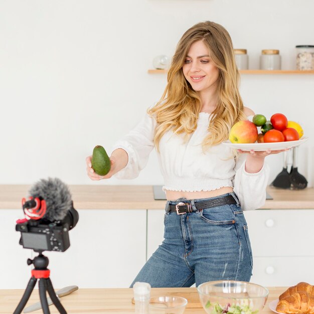 Blogger mujer sosteniendo plato de frutas