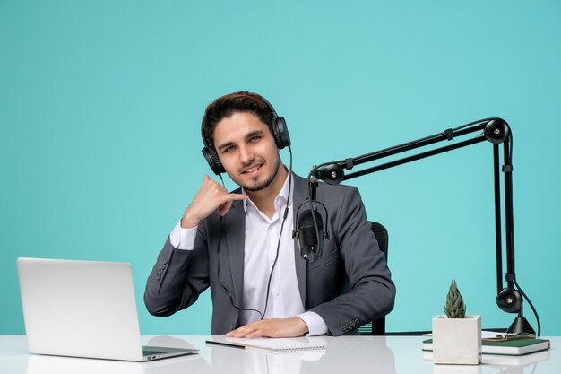 Blogger periodista grabando discurso lindo chico guapo en la oficina haciendo señal de llamada