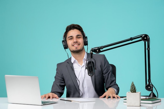 Blogger periodista joven lindo guapo en traje gris grabando video orgulloso