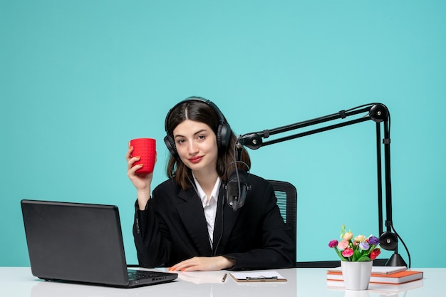 Blogger periodista linda chica bonita en blazer negro grabando discurso en cámara sosteniendo taza roja