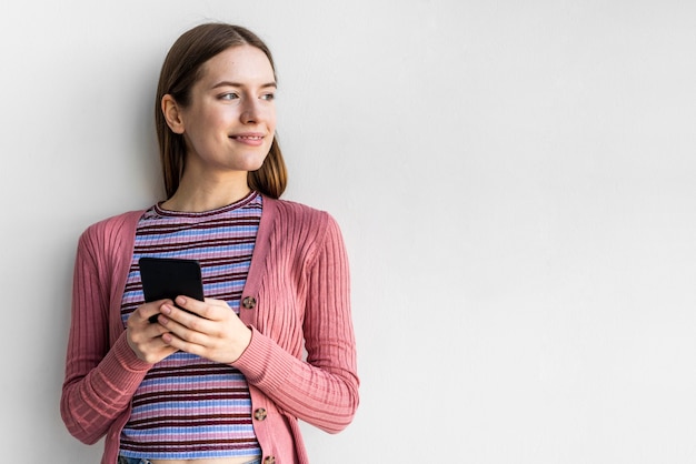 Blogger sosteniendo su teléfono con espacio de copia