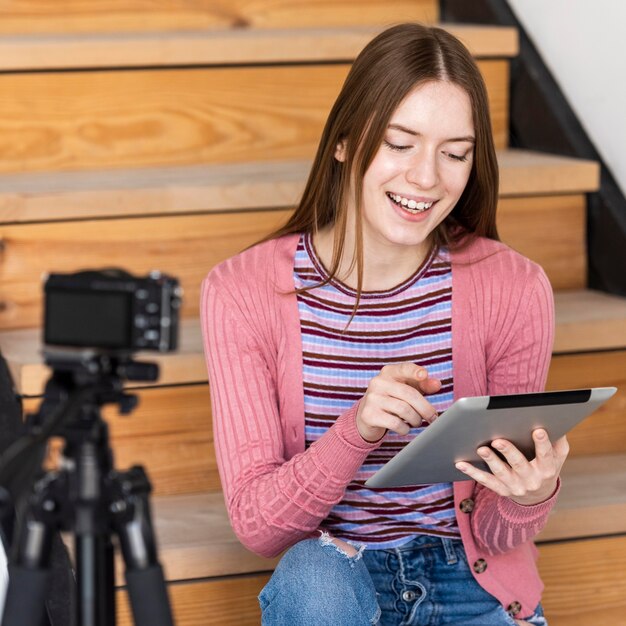 Blogger usando tableta frente a cámara