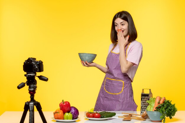 Foto gratuita bloguera de comida linda cocinera fitness grabando video para redes sociales haciendo ensalada