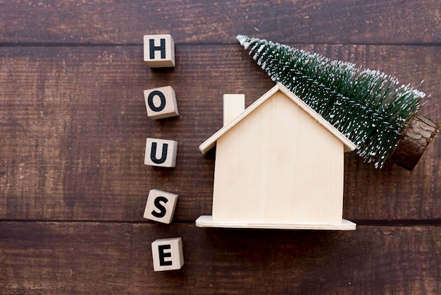 Foto gratuita bloques de casa de palabra con casa de madera y árbol de navidad en mesa