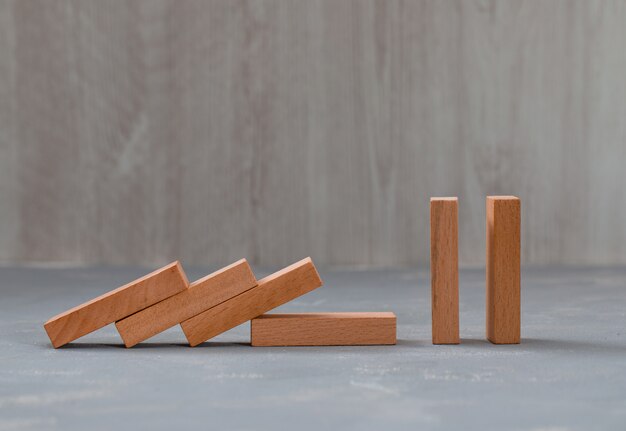 bloques de madera cayendo y de pie sobre yeso y mesa de madera