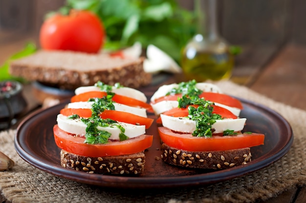 Bocadillos dietéticos útiles con mozzarella, tomate y pan de centeno.