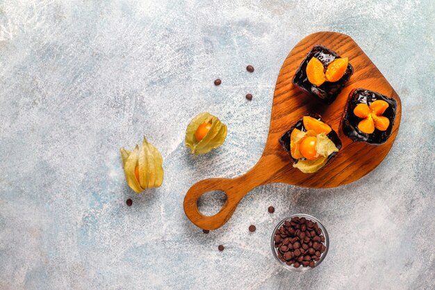 Bocaditos de pastel de chocolate con salsa de chocolate y con frutas, bayas.