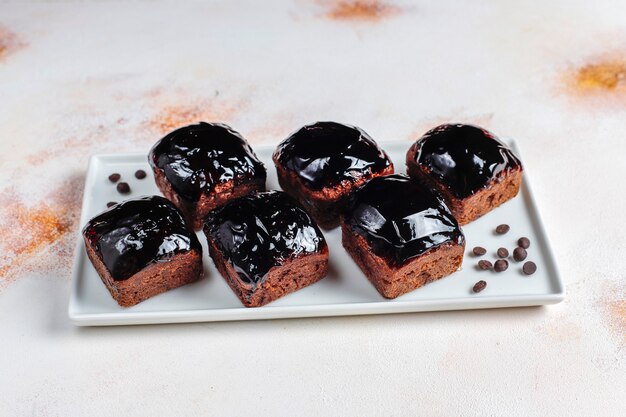 Bocaditos de pastel de chocolate con salsa de chocolate y con frutas, frutos del bosque.