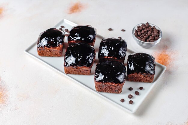 Bocaditos de pastel de chocolate con salsa de chocolate y con frutas, frutos del bosque.