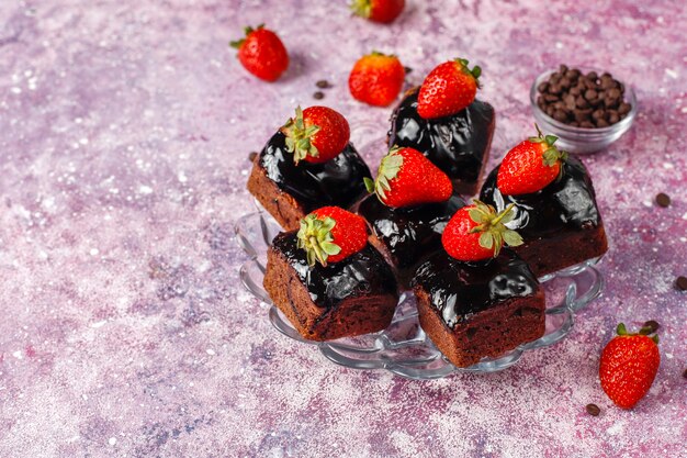 Bocaditos de pastel de chocolate con salsa de chocolate y con frutas, frutos del bosque.