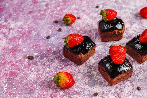 Bocaditos de pastel de chocolate con salsa de chocolate y con frutas, frutos del bosque.