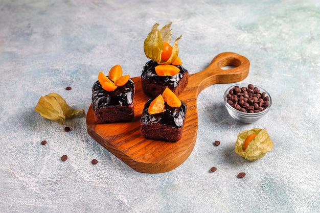Bocaditos de pastel de chocolate con salsa de chocolate y con frutas, frutos del bosque.