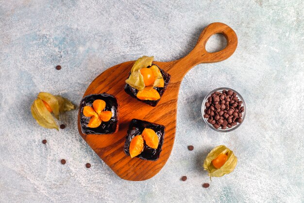 Bocaditos de pastel de chocolate con salsa de chocolate y con frutas.