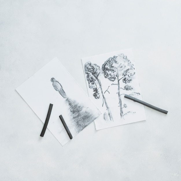Bocetos hermosos y lápiz de carbón de leña aislados en el fondo blanco