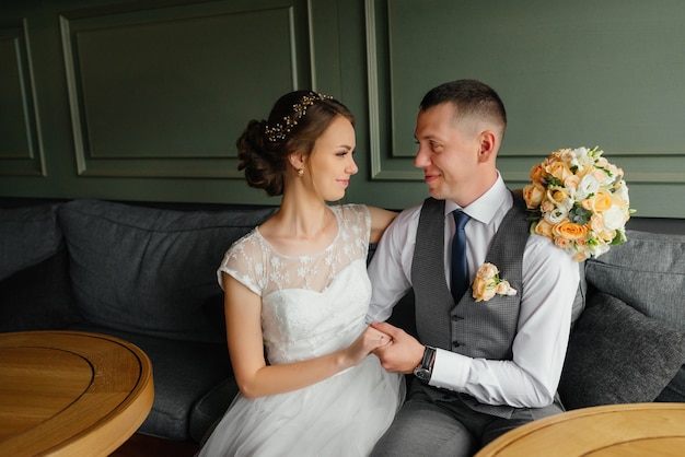 Boda. Día de la boda. La novia hermosa y el novio elegante miran uno a en interior.