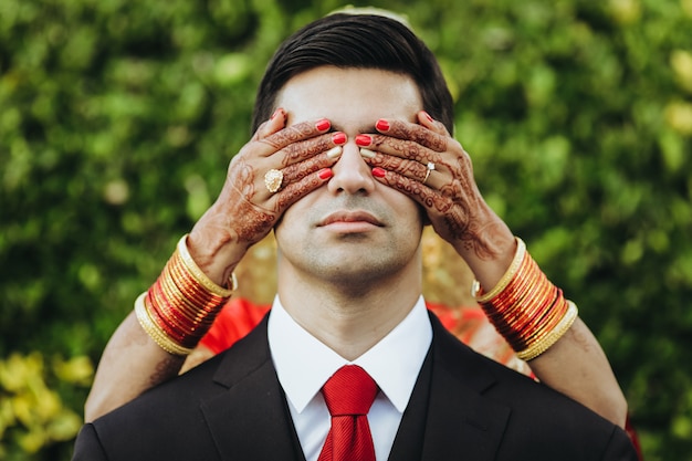 Foto gratuita boda tradicional hindú. la novia abraza al novio tierno por detrás