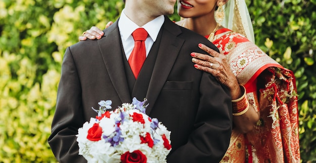 Boda tradicional hindú. La novia abraza al novio tierno por detrás