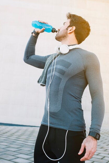 Bode hidratante del hombre deportivo después del entrenamiento
