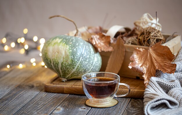 Bodegón acogedor con té y artículos decorativos, luces brillantes de fondo.