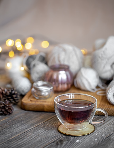 Bodegón acogedor con té y artículos decorativos, luces brillantes de fondo.