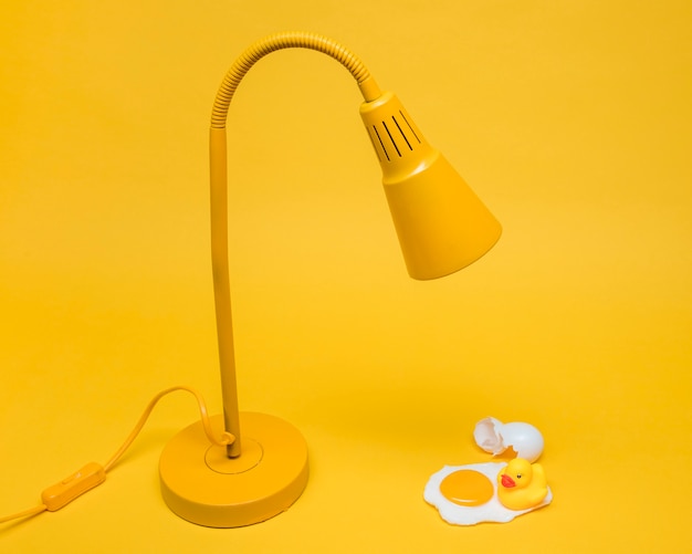 Foto gratuita bodegón amarillo de huevo debajo de lámpara