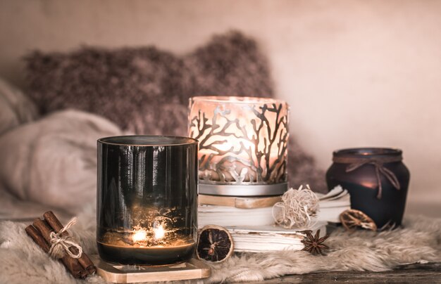 Bodegón ambiente hogareño en el interior con velas y un libro sobre la mesa de colchas acogedoras