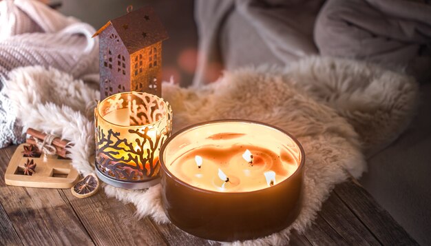 Bodegón casero en el interior con hermosas velas, en el fondo de una acogedora decoración para el hogar