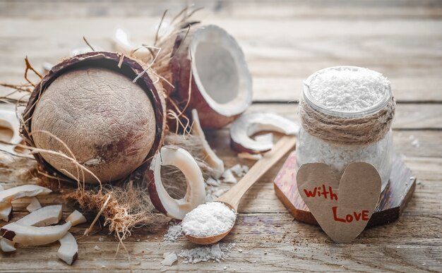 Bodegón día de San Valentín con coco y corazón, cucharas de madera con coco sobre fondo de madera