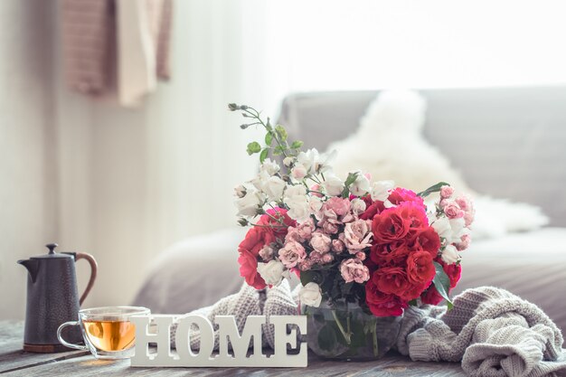 Bodegón con una inscripción en casa y un jarrón de flores.