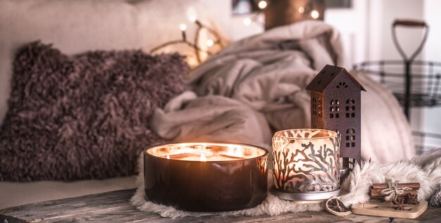 Bodegón en el interior con hermosas velas, sobre la mesa de una acogedora decoración del hogar