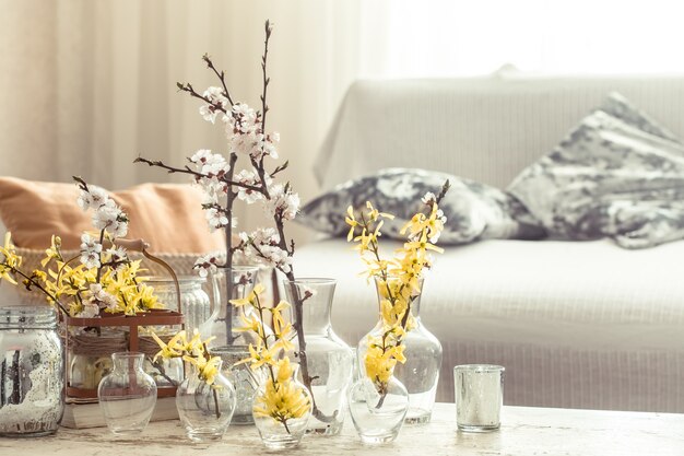 Bodegón con jarrones con flores de primavera en el salón.