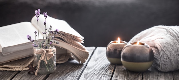 Foto gratuita bodegón un libro y una vela en una pared de madera