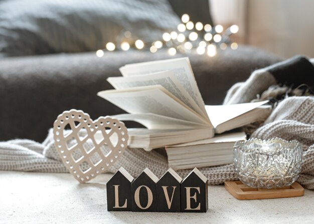 Bodegón con madera palabra amor, libros y artículos acogedores.