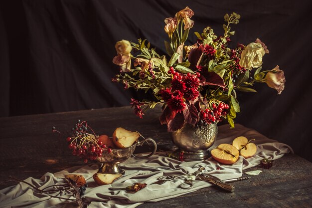 Bodegón con manzanas y flores de otoño.