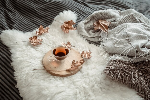 Bodegón otoñal con hojas y una taza de té.