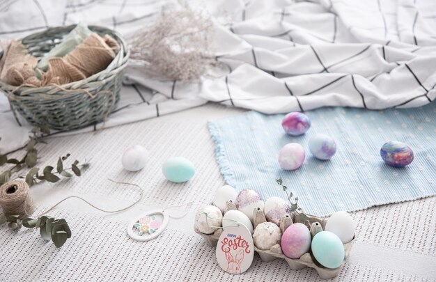 Bodegón de Pascua con una bandeja de huevos festivos y elementos decorativos.
