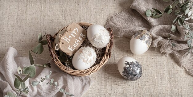 Bodegón de Pascua con huevos en una canasta de mimbre. Concepto de Pascua feliz.