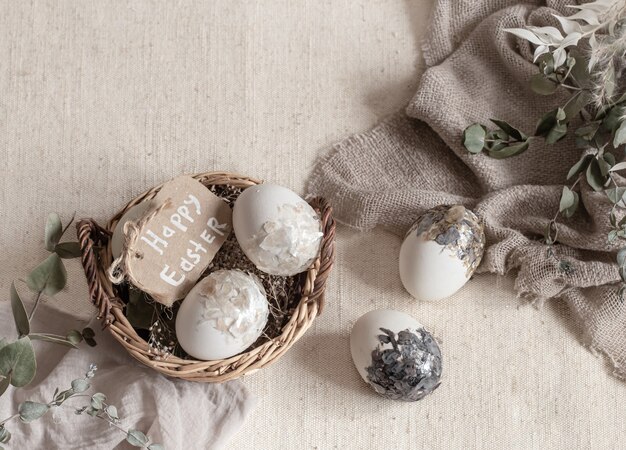 Bodegón de Pascua con huevos en una canasta de mimbre. Concepto de Pascua feliz.