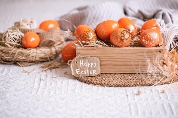 Bodegón de Pascua con huevos de naranja, decoración de vacaciones.