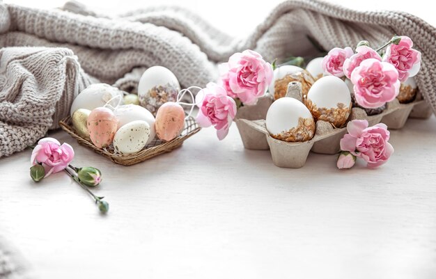 Bodegón de Pascua con huevos de Pascua, flores frescas y elementos decorativos de cerca.