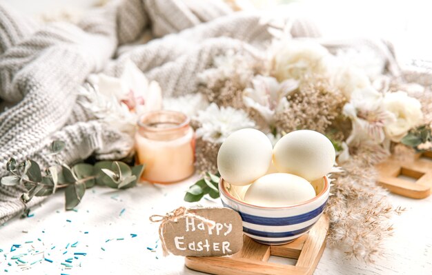 Bodegón de primavera con huevos de Pascua en un hermoso platillo contra detalles decorativos. Concepto de vacaciones de semana Santa.