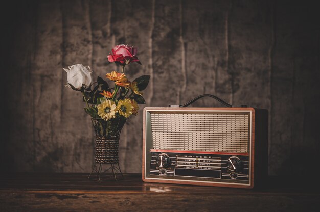 Bodegón con un receptor de radio retro y floreros