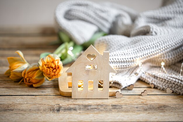 Bodegón romántico casero con detalles de decoración y elemento tejido sobre fondo borroso con bokeh.