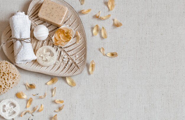 Bodegón de spa con accesorios de baño para el cuidado del cuerpo entre pétalos de flores vista superior. Concepto de salud e higiene.