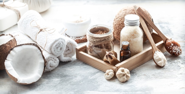 Bodegón de spa con coco fresco y productos para el cuidado corporal
