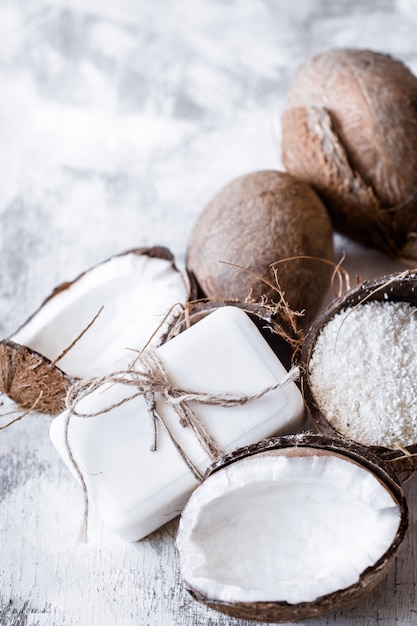 Bodegón de spa de cosmética orgánica con cocos sobre un fondo de madera clara, concepto de cuidado corporal